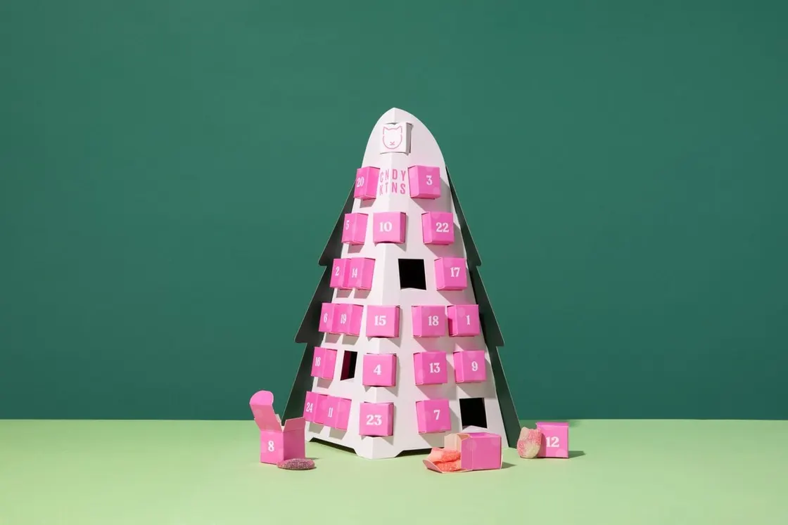 Tree-shaped Candy Kittens advent calendar with pink numbered doors and sweets spilling from the open ones