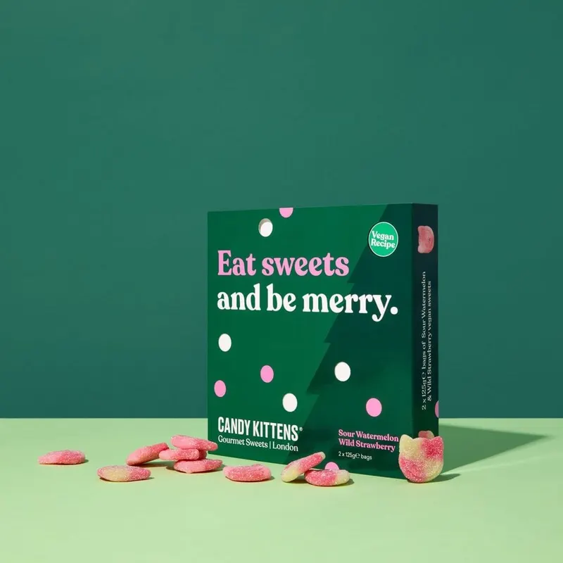 Green Candy Kittens carton printed "Eat sweets and be merry" with sweets scattered around it