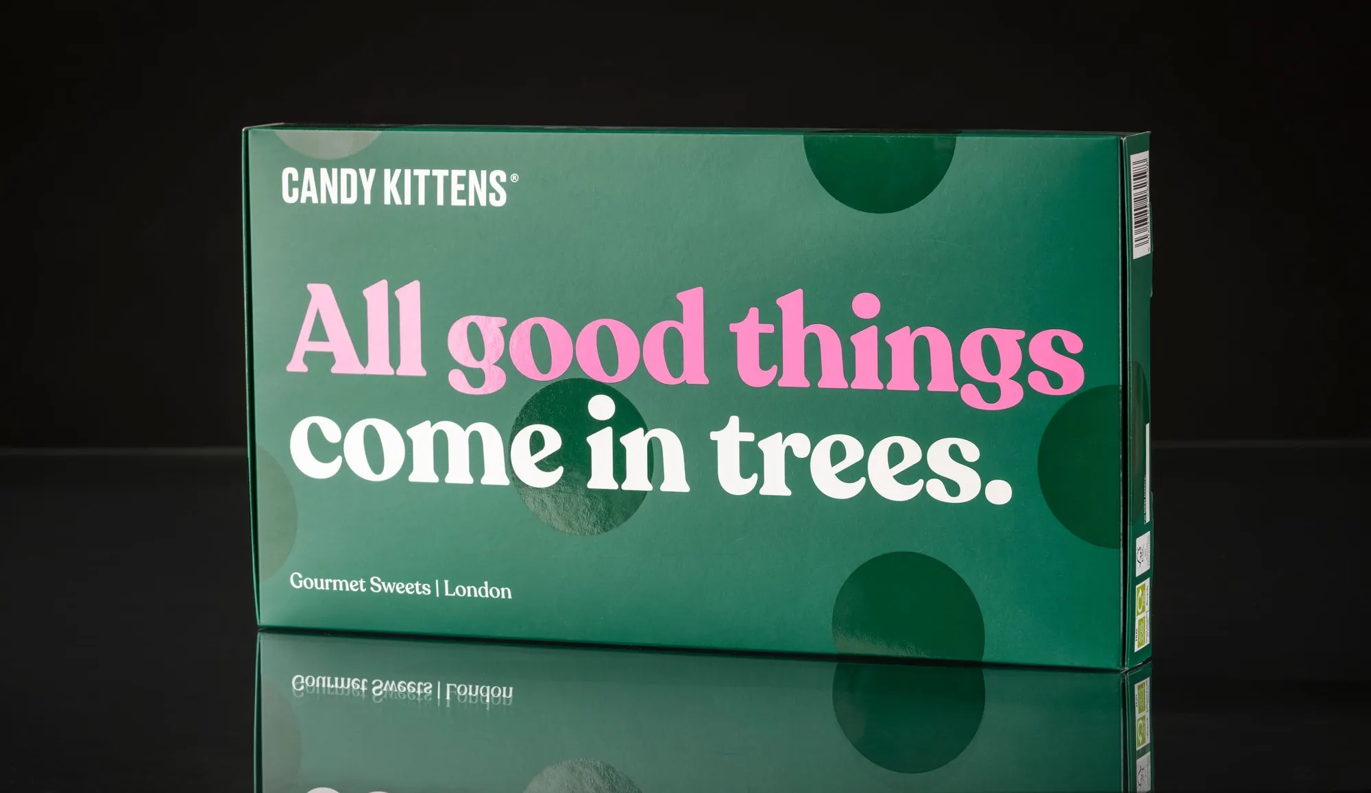 Dark green Candy Kittens carton printed "All good things come in trees", on a black reflective ground