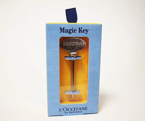 Blue L'Occitane Magic Key carton with a die-cut window framing the foil-blocked key inside