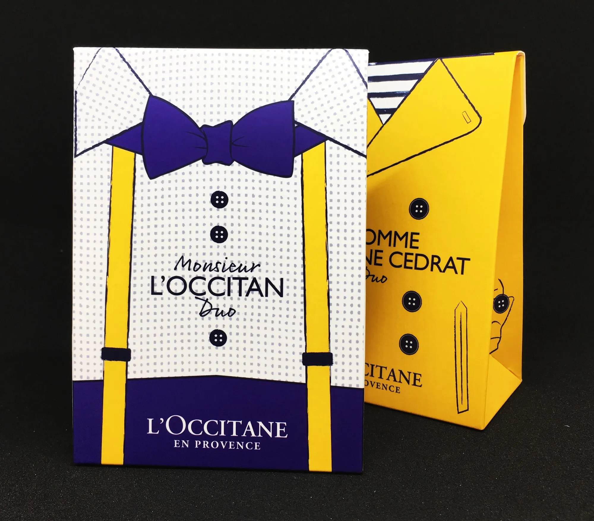 Monsieur L'Occitane duo carton printed as a shirt and bow tie, beside a yellow carton printed as a jacket