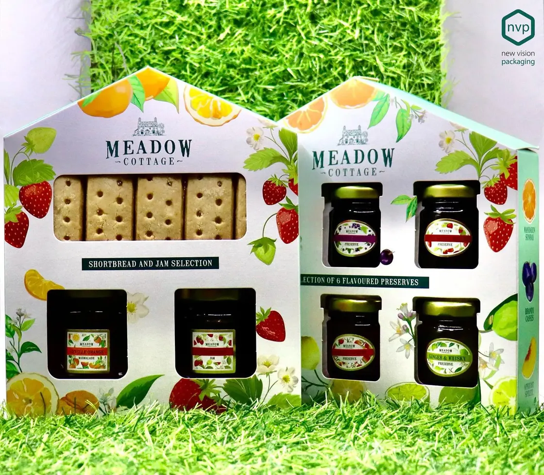 Two house-shaped Meadow Cottage cartons presenting preserves and shortbread behind die-cut windows