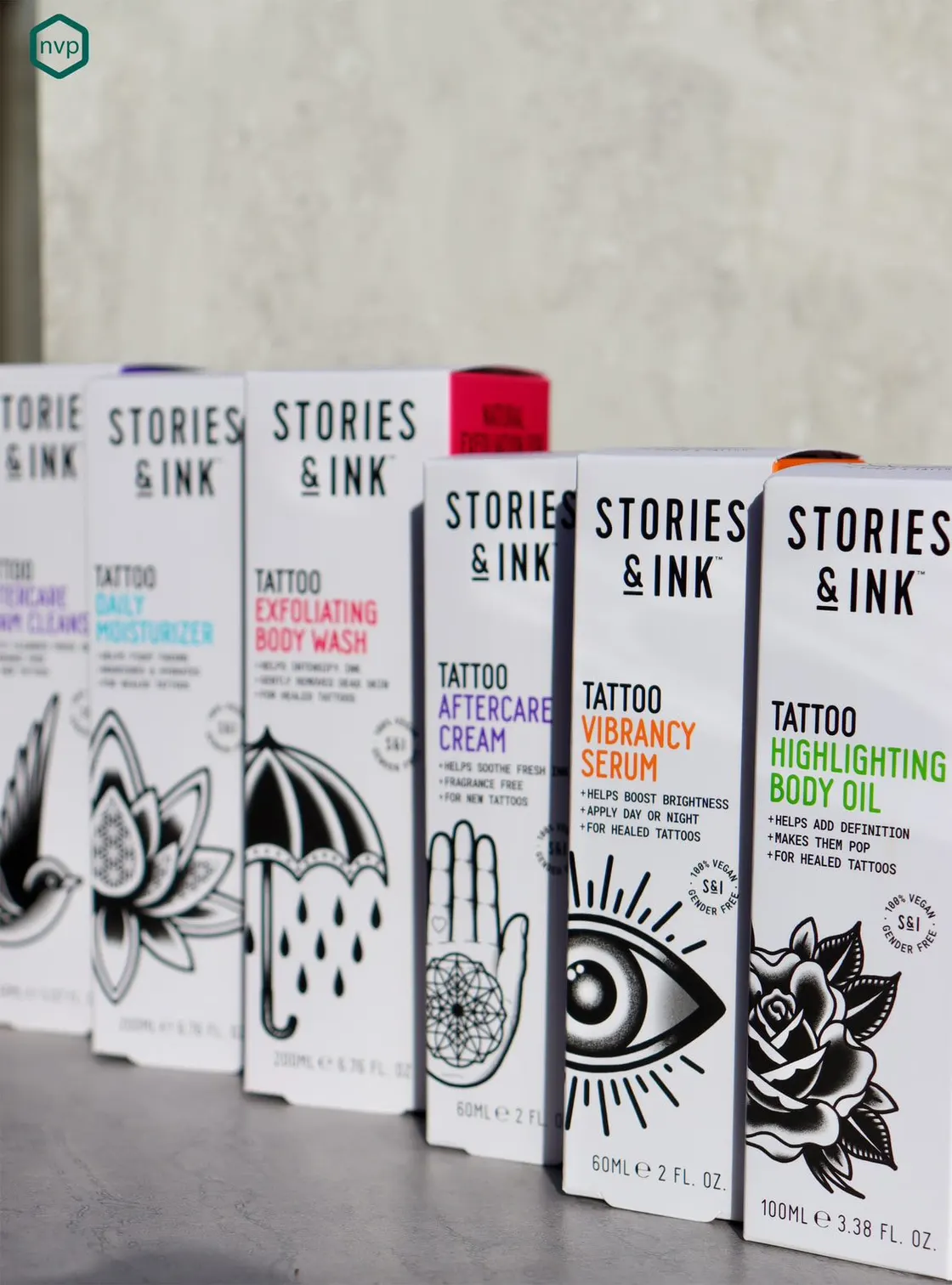 The Stories & Ink tattoo aftercare range in white cartons, each printed with a different line-drawn tattoo