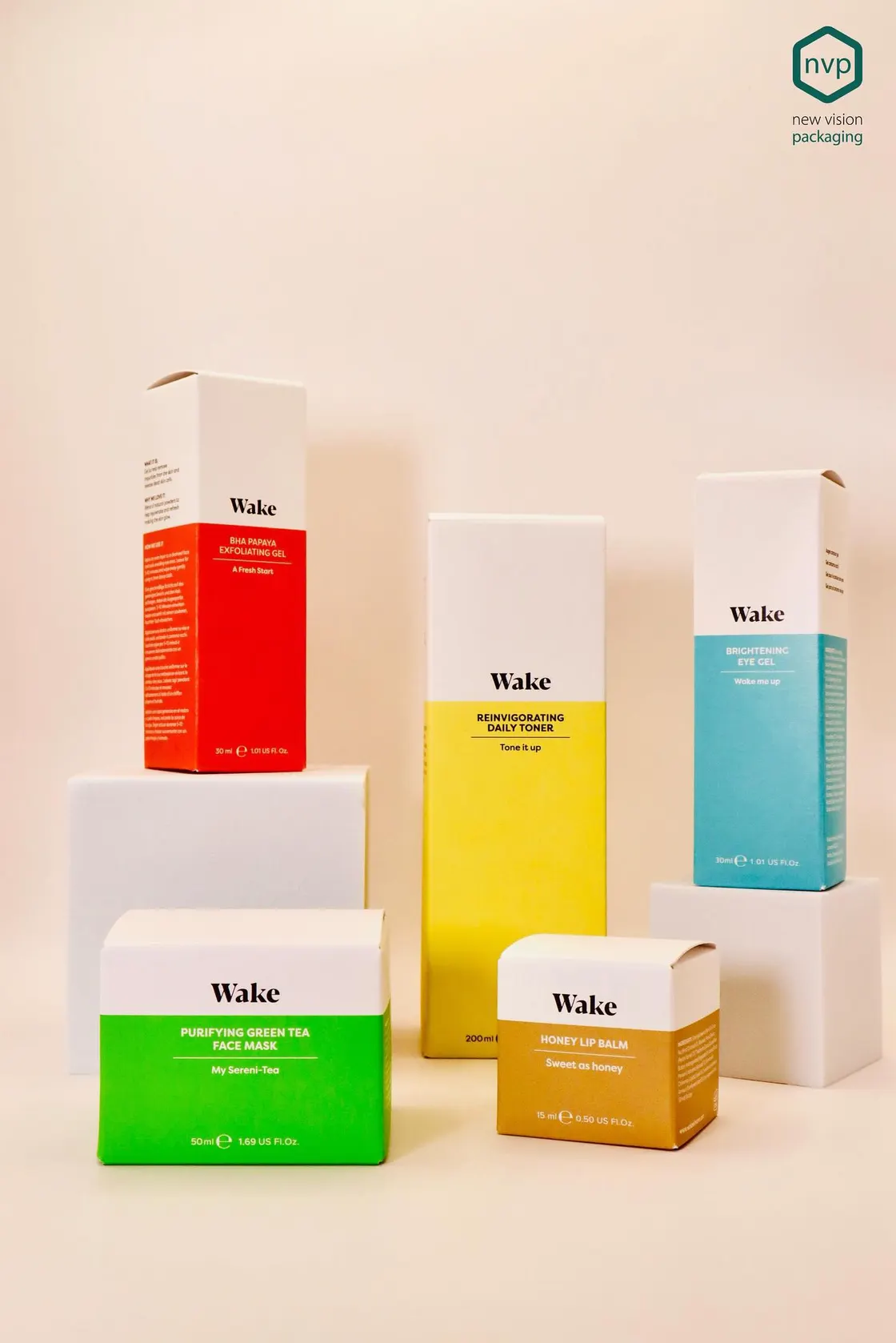 The Wake skincare range in white, red, yellow and green cartons, arranged on white plinths