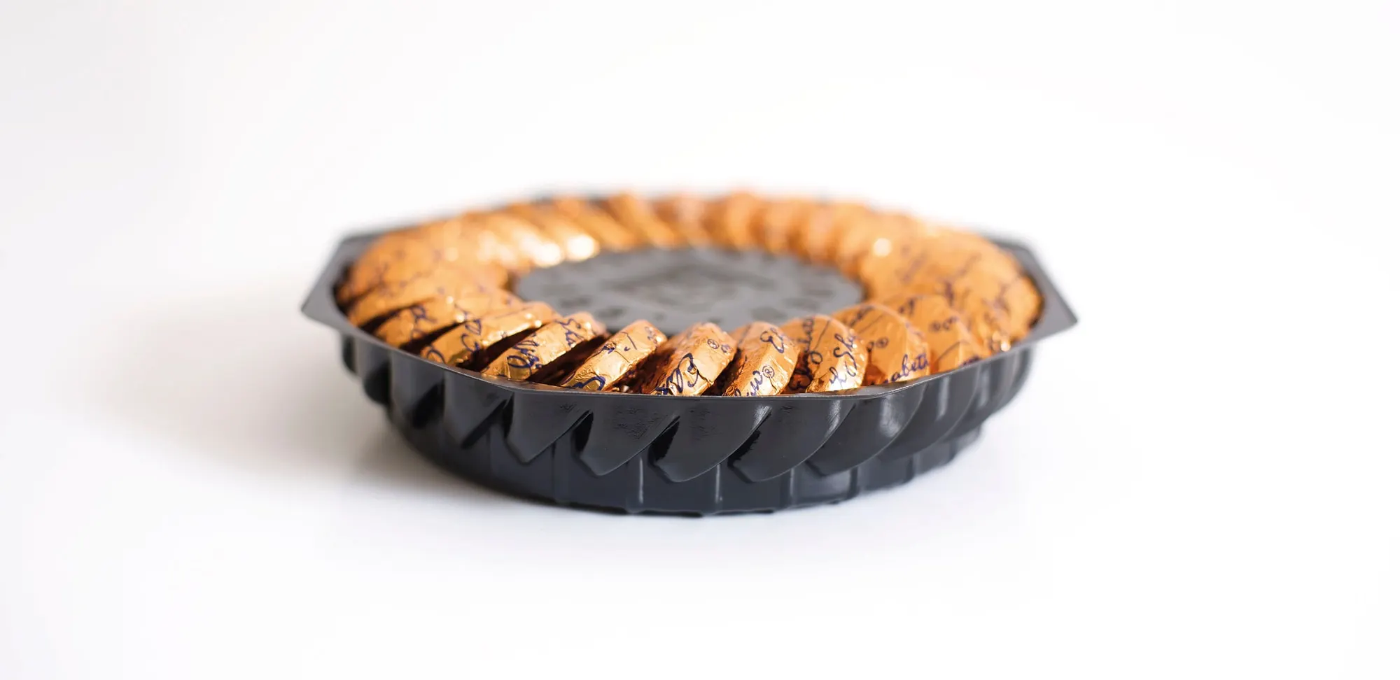 Round scalloped vacuum formed tray presenting a biscuit-edged caramel tart